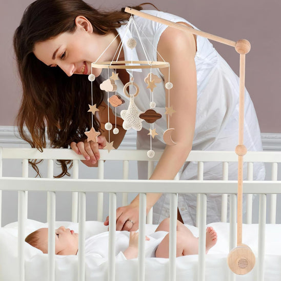 maman qui berce son bébé en s'aidant du mobile bébé