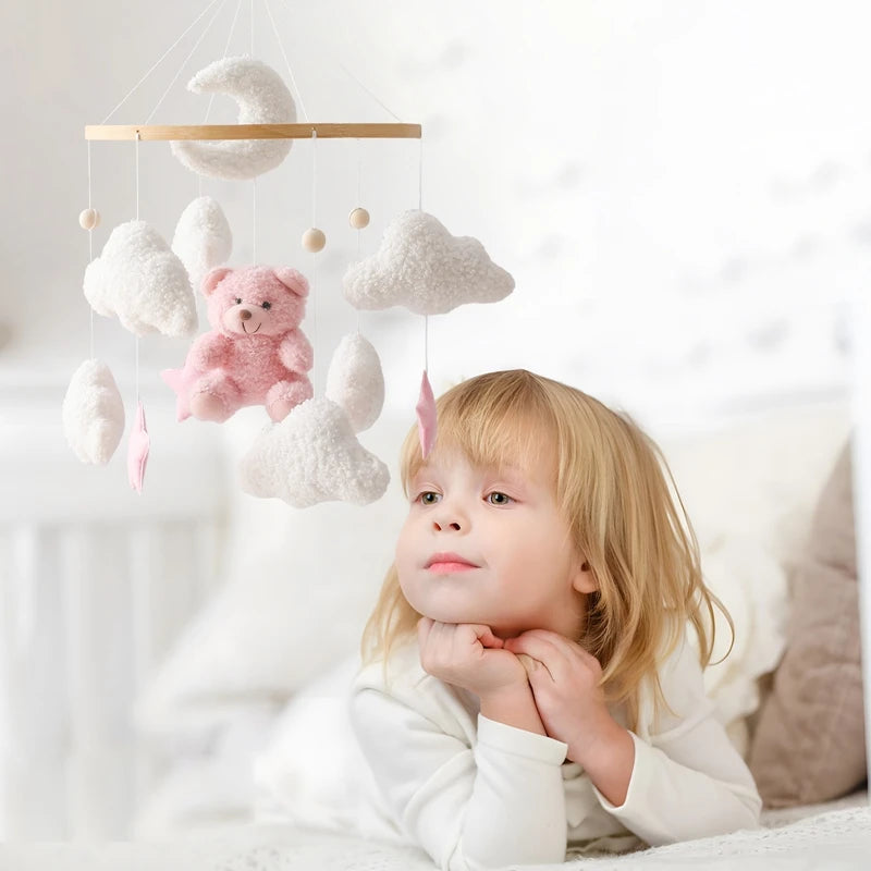 un garçon dans son lit regardant le mobile bebe bois