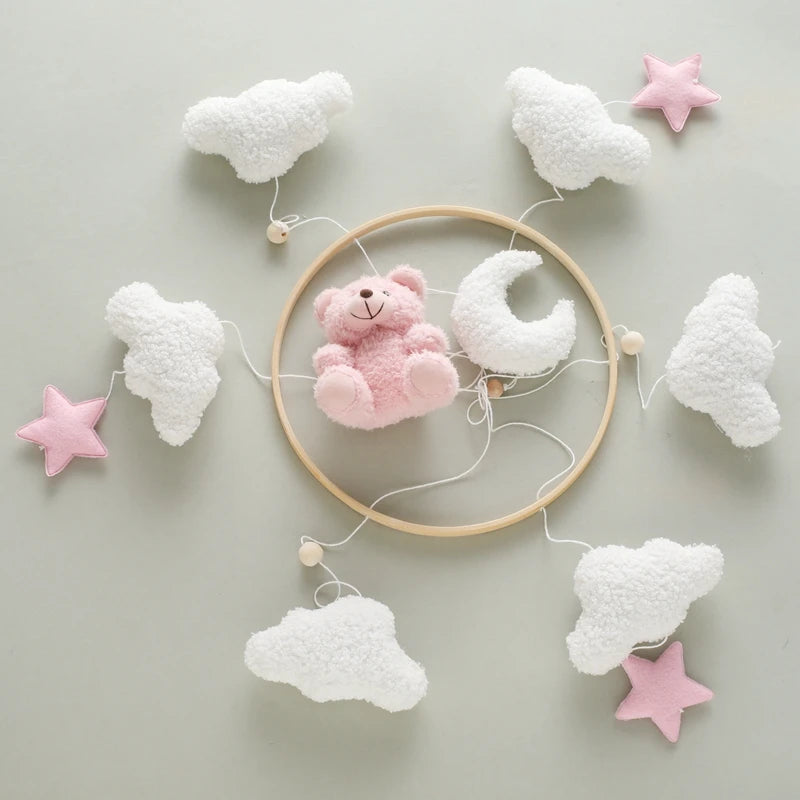 le mobile bebe ours rose est détaillé avec ses éléments de nuages et étoiles