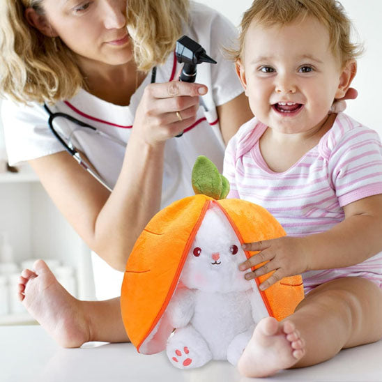 un bébé calme avec sa peluche lapin Flip et Flap avec une infirmiÚre qui l'ausculte