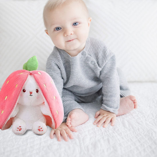 un petit garçon content avec sa peluche lapin fraise