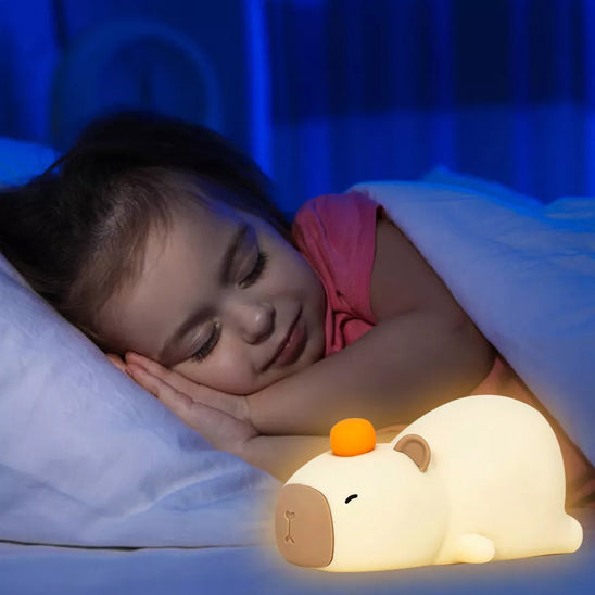 veilleuse bébé forme capybara qui eclaire une petite fille qui dort