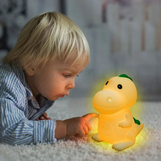 un petit garçon blond qui allume la veilleuse pour bebe avec le doigt