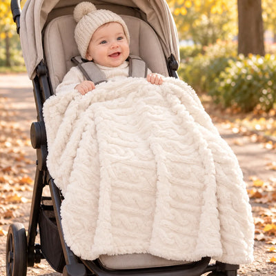 Bébé enveloppé dans la couverture poussette Nuage crème lors d’une promenade
