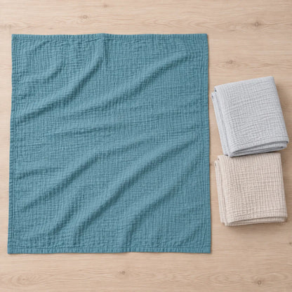 Couverture bleue dépliée à côté des couvertures beige et gris perle pliées du Trio Rivage.