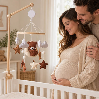 Futurs parents admirant le mobile Escale sur la Lune près d’un lit vide dans une chambre aux tons naturels.