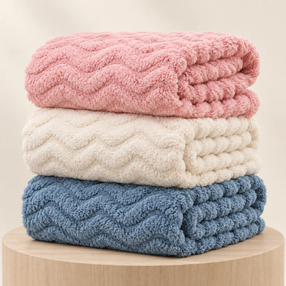 Couvertures bébé Nuage empilées dans les coloris rose, crème et bleu