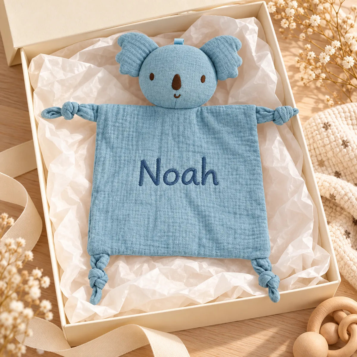 Doudou koala bleu personnalisé présenté comme cadeau de naissance