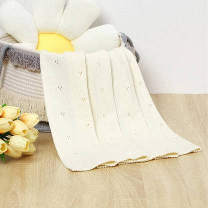 couverture-bebe-tricot-beige-dans-un-panier-a-fleur