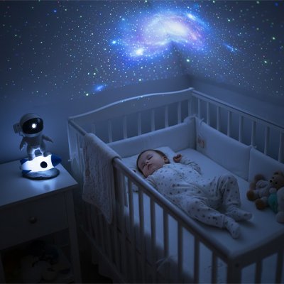 bébé dans son berceau sous la lumiere de la galaxie de la Veilleuse projection 