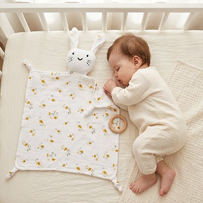 bébé dort paisiblement avec son Doudou lapin dans le lit