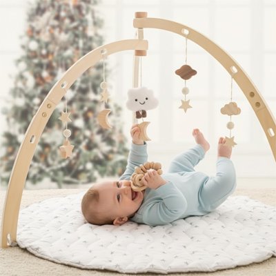 un bébé avec sa barboteuse bleu jour sous l'arche d'éveil durant les temps des fêtes