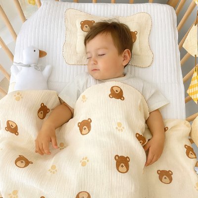 bébé qui dort paisiblement dans son lit sous la Couverture bébé ourson