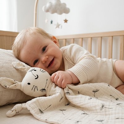 bébé tout content de jouer avec son Doudou lapin