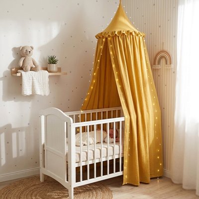 Ciel de lit couleur jaune qui couvre le lit de bébé
