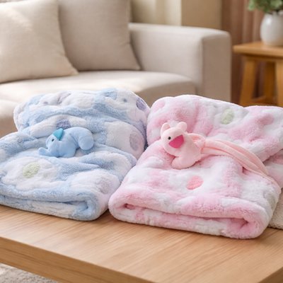 Couverture bébé bleu et rose posées sur la table