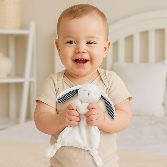 un garçon joue avec son doudou bébé