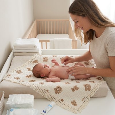 Maman qui habille son bébé et le protege du froid avec la Couverture bébé 