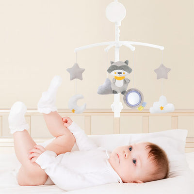 un bébé allongé dans son lit avec le mobile bebe