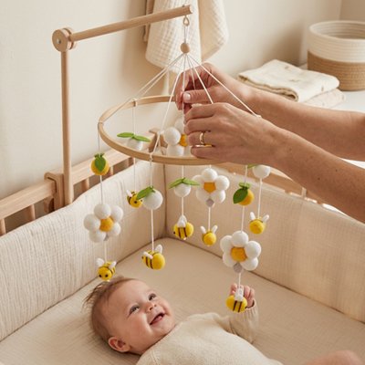 Mobile bébé style abeille jaune fixé sur le lit bébé