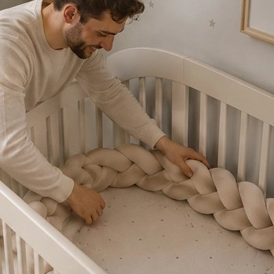 Papa installe la Tresse de lit sur le lit de bébé