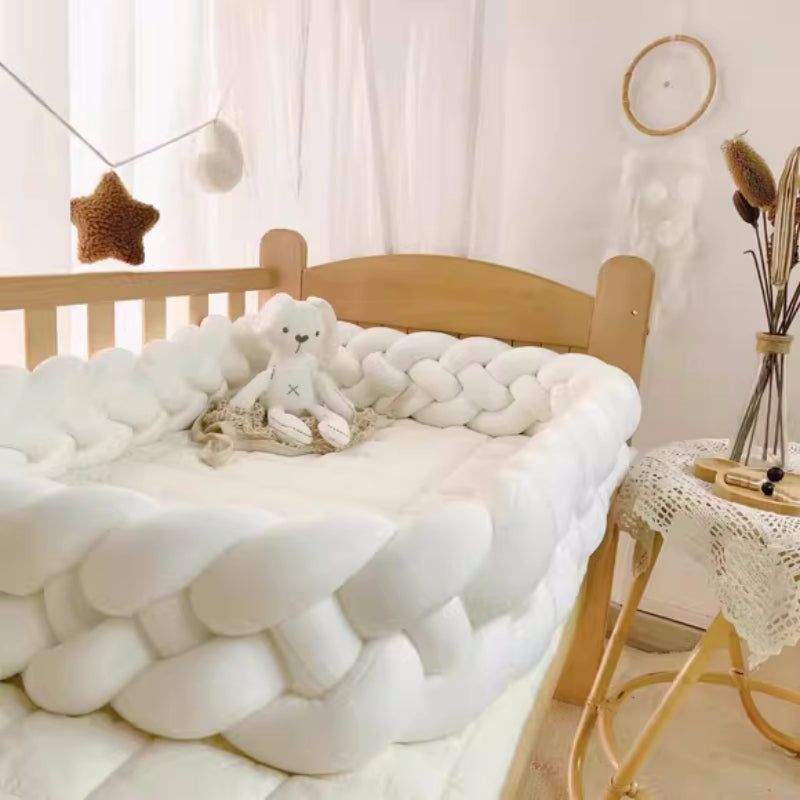 une belle tresse de lit blanche est posée sur le lit bébé