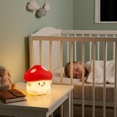Veilleuse bébé champignon sur table de nuit a coté de bébé qui dort 