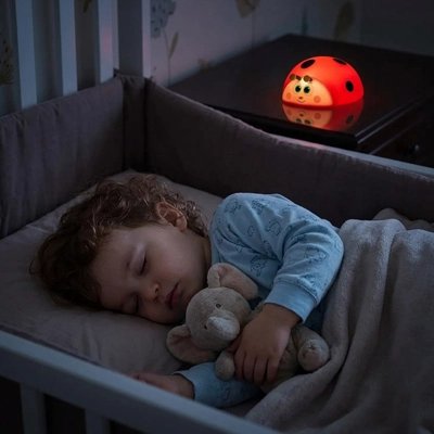 Veilleuse bébé coccinelle qui illumine bébé pendant qu'il dort