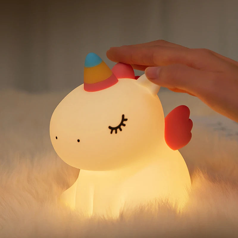 une main qui allume la veilleuse licorne