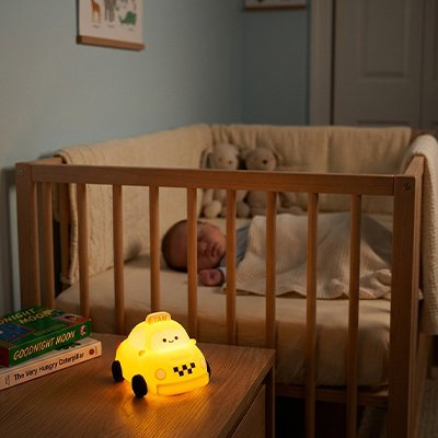 Veilleuse bebe taxi bébé qui dort dans le berceau sous la lumiere de la veilleuse