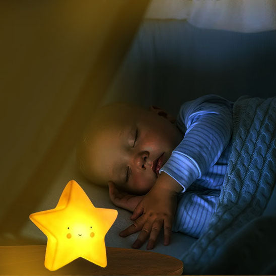 un bébé qui dort paisiblement sous la lumière de la veilleuse en forme d'étoile