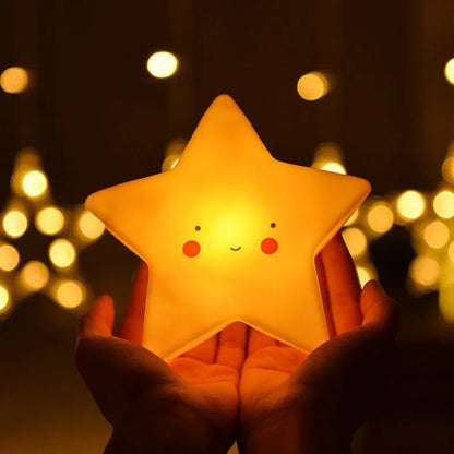 une personne prend la veilleuse en forme d'étoile stella entre ses mains