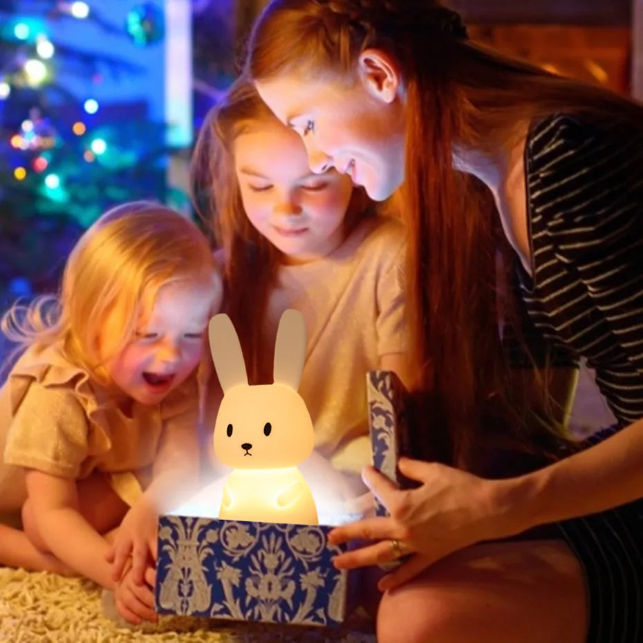 une jolie fille qui découvre son cadeau qui est la veilleuse Lapinou