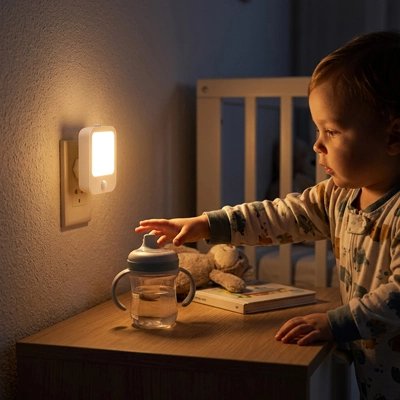 Veilleuse murale bébé attrape son biberon le soir en s'aidant de la veilleuse murale