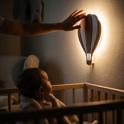 Veilleuse murale dams la chambre cozy de bébé qui s'aprete a dormir