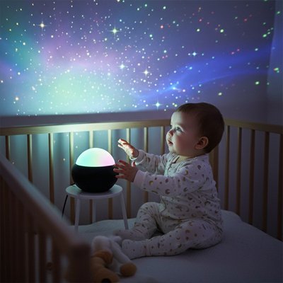 Veilleuse projection éclaire la chambre de bébé pendant qu'il est dans son lit